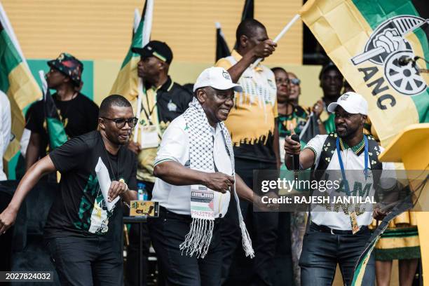 African National Congress and South African President Cyril Ramaphosa sings and dnaces on stage wearing a chequered scarf with the word Palestine...