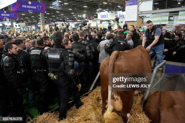 French Police officers follow France's President as he tours the exhibition on the opening day of the 60th International Agriculture Fair , at the...