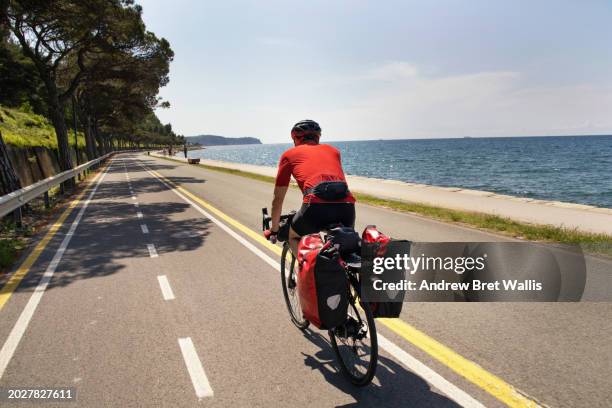 male touring cyclist rides a cycle path alongside the adriatic coast - adriatic sea stock pictures, royalty-free photos & images