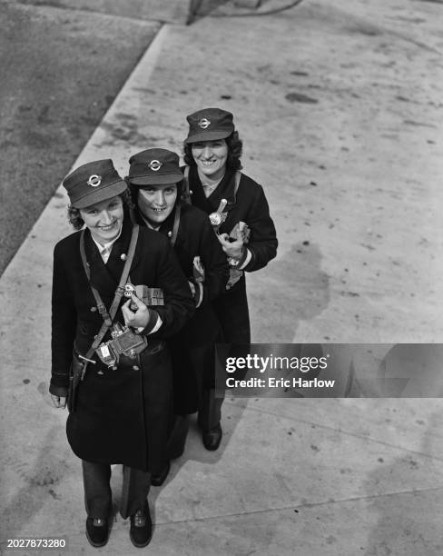 Three sisters who are working together as LPTB conductors, London, UK, 27th May 1942; they are V Fraser, Joan Stone , and Ellen Hennell .