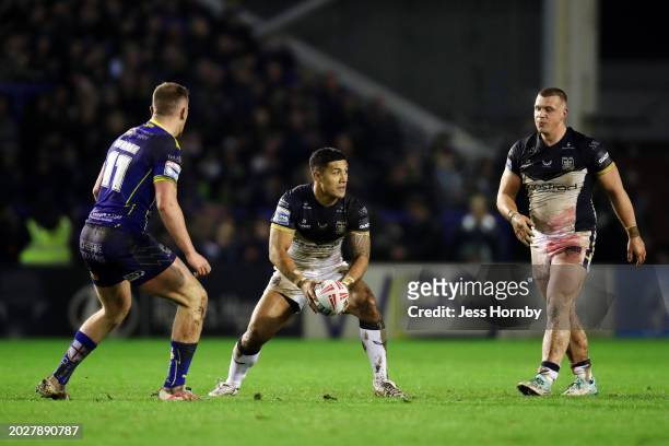 Fa'amanu Brown of Hull FC runs with the ball whilst under pressure from Ben Currie of Warrington Wolves during the Betfred Super League match between...