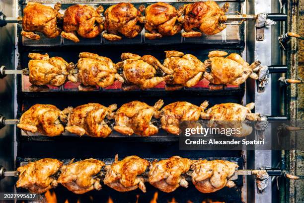 rotisserie chicken spinning on the grill - spit roasted stock pictures, royalty-free photos & images