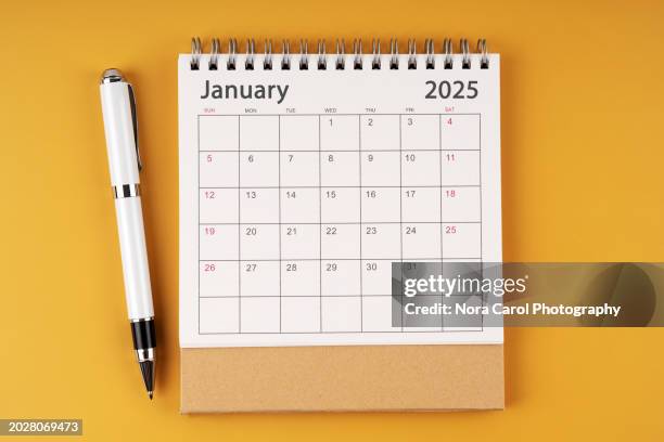 january 2025 desk calendar on yellow background - verval stockfoto's en -beelden