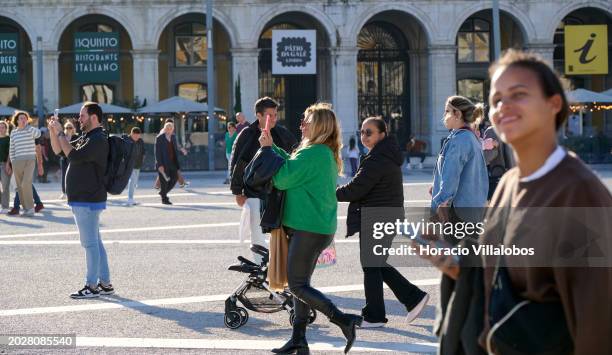 Visitors take pictures using their cellphones in Praça do Comercio, a favorite tourist spot, on February 19 in Lisbon, Portugal. Tourism generated 25...