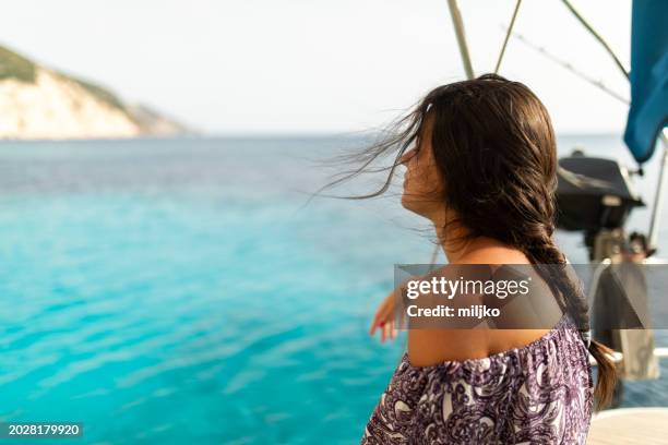 young woman relaxing on a sailboat - feeling the breeze stock pictures, royalty-free photos & images