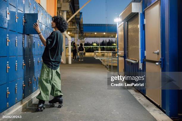 woman on roller skates looking in a parcel locker - attitude stock pictures, royalty-free photos & images