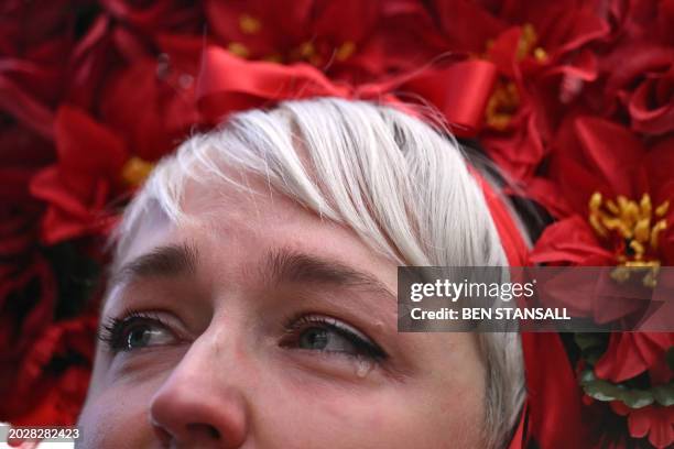 Woman wearing traditional Ukrainian dress, sheds a tear at a vigil in Trafalgar Square, in London on February 24 to mark 2 years since the beginning...