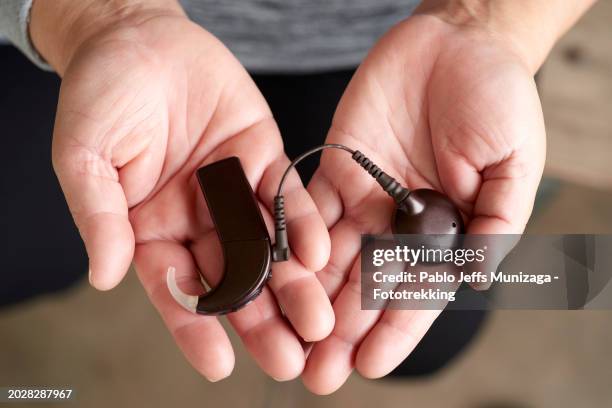 hands holding a cochlear implant - assistive technology stock pictures, royalty-free photos & images