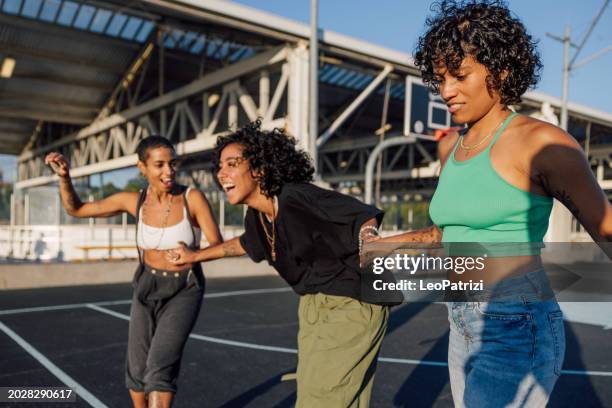 friends on quad roller skates enjoying dancing together - attitude stock pictures, royalty-free photos & images