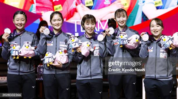 Japan's Miwa Harimoto, Miyuu Kihara, Miu Hirano, Hina Hayata and Mima Ito pose after winning silver in the women's event at the world team table...
