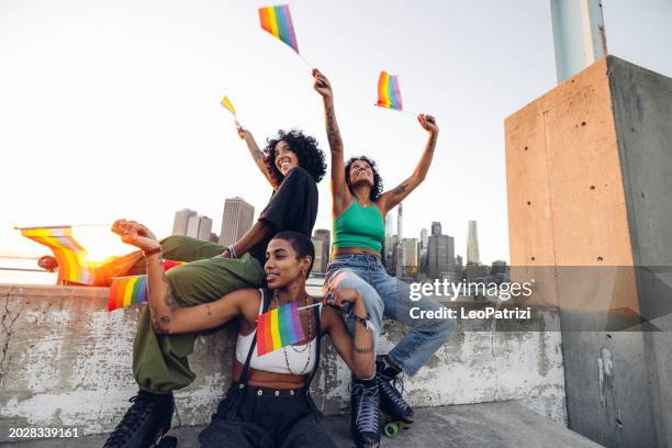 freestyler roller skate dancers performing for lgbtqia+ rights holding rainbow flags - pride month stock pictures, royalty-free photos & images