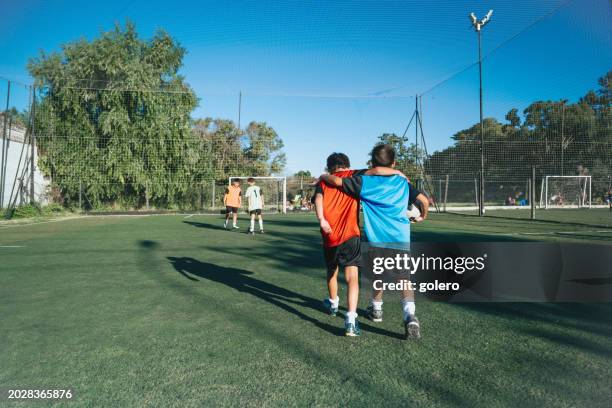 two boys from opponent teams walking embraced  after match - finals game two stock pictures, royalty-free photos & images