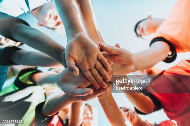 boy soccer team standing in circle and putting hands together - huddling stock pictures, royalty-free photos & images