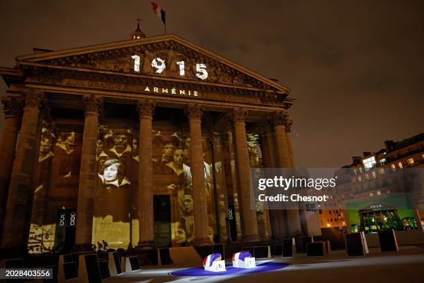 Coffins of Missak Manouchian and his wife Mélinee Manouchian lay outside the Pantheon monument as images are projected during the induction ceremony...