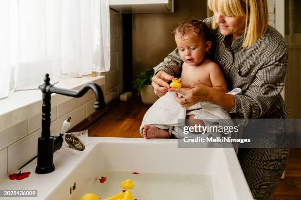 baby boy playing with live birth duck in the kitchen sink - dodging stock pictures, royalty-free photos & images