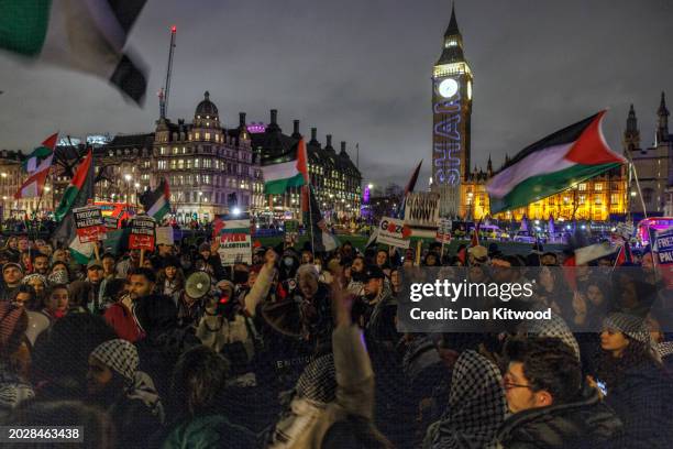 People hold placards and Palestinian flags during a rally calling for a ceasefire, outside parliament as MPs consider a motion on Gaza on February...