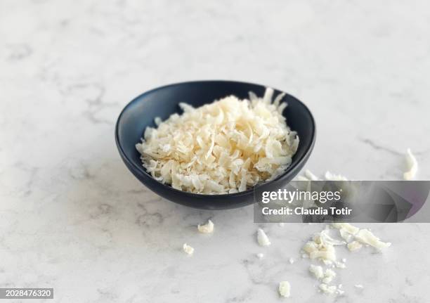 bowl of grated parmesan cheese on white background - grated stock pictures, royalty-free photos & images