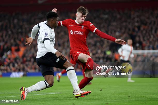 Conor Bradley of Liverpool is challenged by Chiedozie Ogbene of Luton Town during the Premier League match between Liverpool FC and Luton Town at...