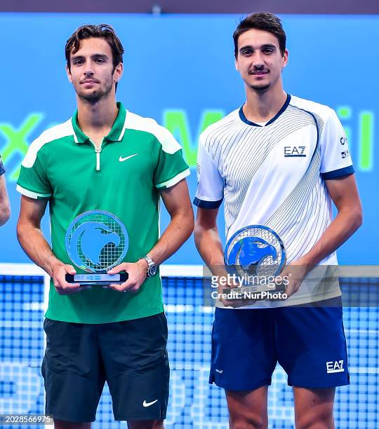 Lorenzo Musetti and Lorenzo Sonego of Italy are holding their runner-up trophies after losing the doubles final to Jamie Murray of Great Britain and...