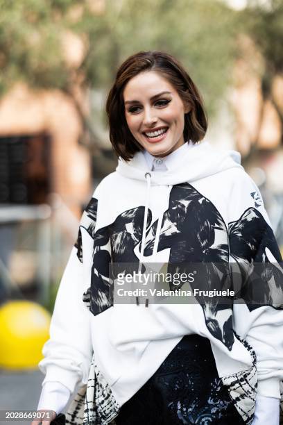 Olivia Palermo is seen wearing a black midi lace skirt, a white shirt and a black and white printed hoodie outside the Antonio Marras show during the...