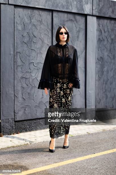 Francesca Busi is seen wearing black sunglasses, black pumps, a black bra, a black see-through shirt with lace applications, black pants and a...