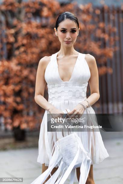 Heart Evangelista is seen wearing silver bracelets, a white intertwined handbag with long fringes and a white v-neck mini intertwined dress outside...