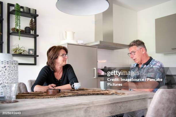 wife preparing lunch for her husband whos is sitting in his wheel chair at the table - man wheel chair stock pictures, royalty-free photos & images