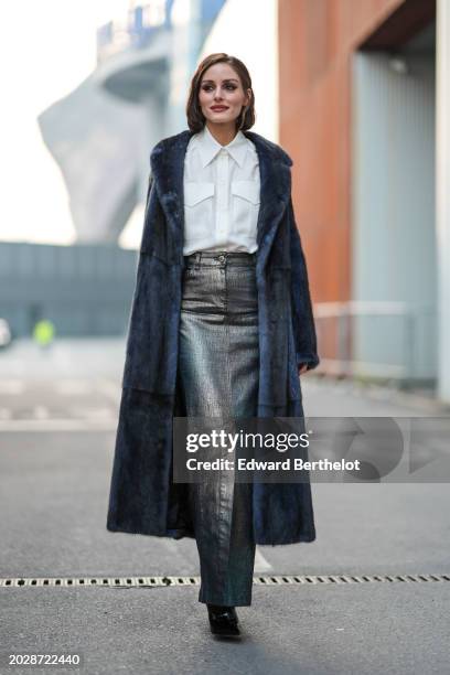 Olivia Palermo wears a white shirt, a blue fluffy long coat, a blue and silver shiny denim slit skirt , thigh high leather pointed boots with high...