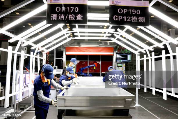 Workers are producing structural components of power batteries for new energy vehicles at a production workshop of an intelligent manufacturing...