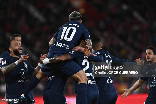 Atletico Madrid's Argentinian forward Angel Correa celebrates scoring the opening goal, with teammates, during the Spanish league football match...