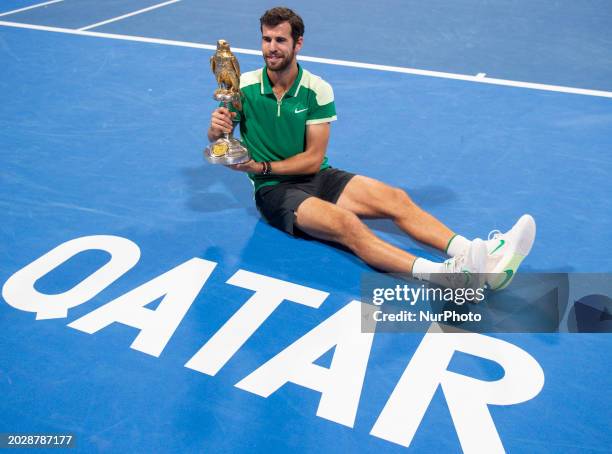 Karen Khachanov is posing with the trophy after winning the ATP Qatar ExxonMobil Open tennis tournament final against Jakub Mensik of the Czech...