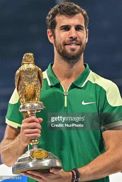 Karen Khachanov is posing with the trophy after winning the ATP Qatar ExxonMobil Open tennis tournament final against Jakub Mensik of the Czech...