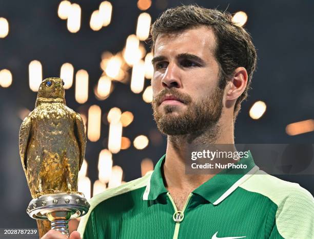 Karen Khachanov is posing with the trophy after winning the ATP Qatar ExxonMobil Open tennis tournament final against Jakub Mensik of the Czech...