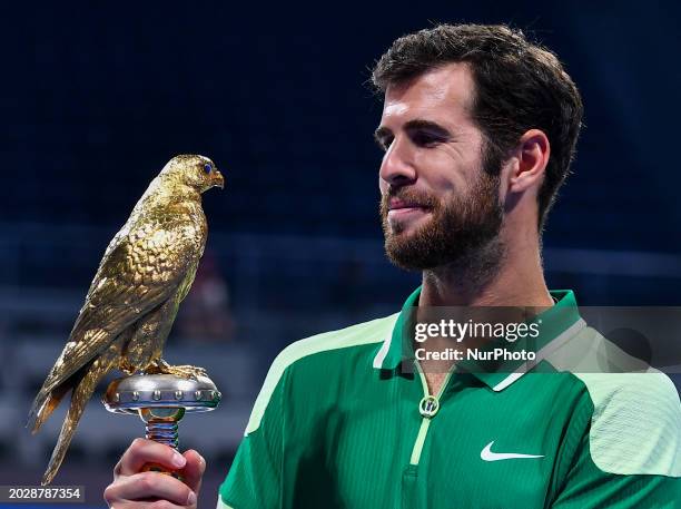 Karen Khachanov is posing with the trophy after winning the ATP Qatar ExxonMobil Open tennis tournament final against Jakub Mensik of the Czech...