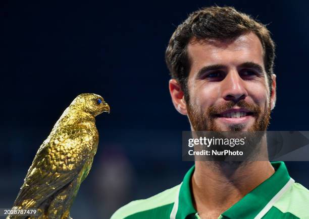 Karen Khachanov is posing with the trophy after winning the ATP Qatar ExxonMobil Open tennis tournament final against Jakub Mensik of the Czech...