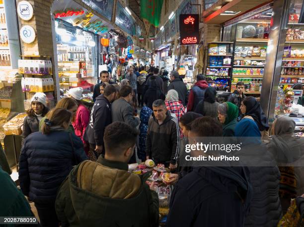 People are purchasing goods from a vendor in the Tajrish traditional bazaar in northern Tehran, Iran, on February 24, 2024. The Iranian Parliament...