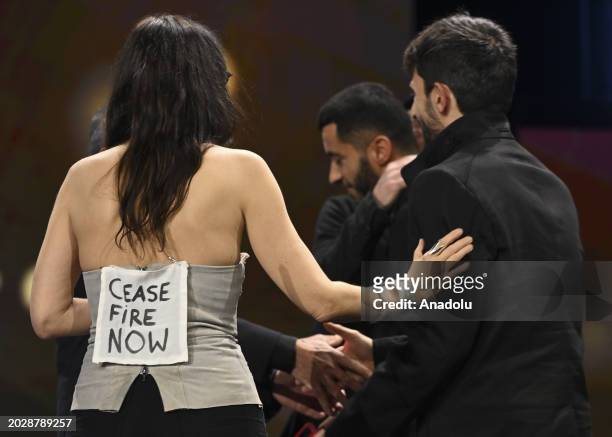 Swiss filmmaker and artist Verena Paravel, carries a writing ''Cease fire now'' on her back at the Award Ceremony of the 74th Berlinale International...