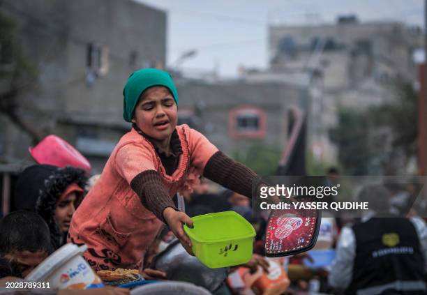 Displaced Palestinians gather to receive food at a donation point in Rafah in the southern Gaza Strip on February 24 after more than four months of...