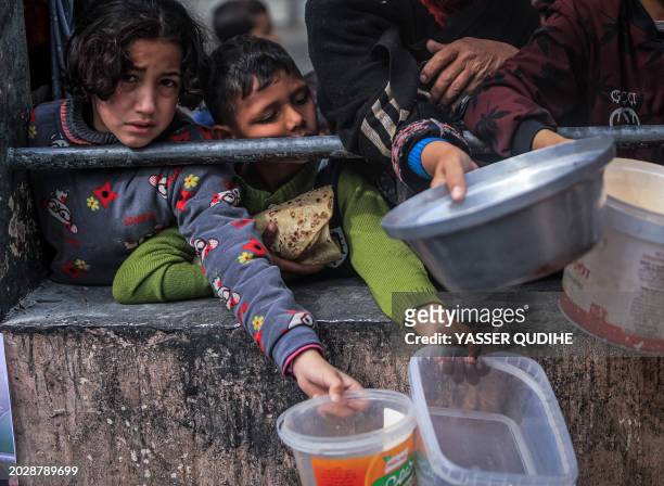 Displaced Palestinians gather to receive food at a donation point in Rafah in the southern Gaza Strip on February 24 after more than four months of...