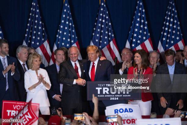 Former US President Donald Trump, center, shakes hands with Henry McMaster, governor of South Carolina, center left, during an election night watch...