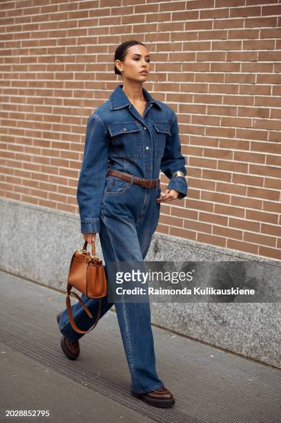 Guest wears blue jeans, a blue denim shirt, and a brown leather bag outside Fendi during the Milan Fashion Week - Womenswear Fall/Winter 2024-2025 on...