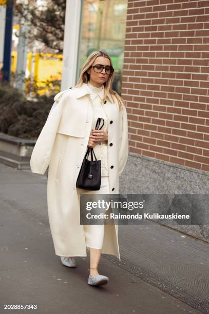 Julia Comil wears a creme or pale yellow coat, the same matching color maxi skirt, top, and a vest, a black Fendi bag, and light pale blue Fendi...