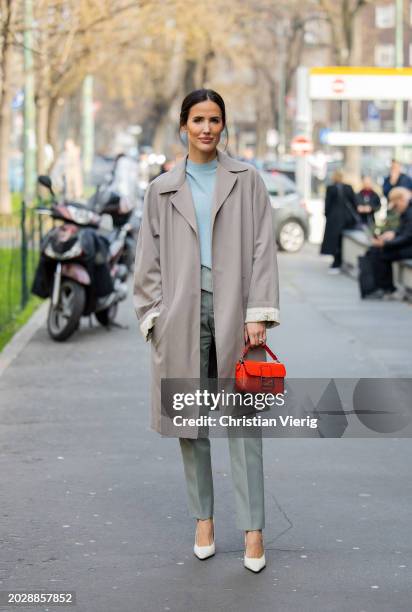 Alex Riviere wears grey coat, red bag, green pants, turquoise top outside Fendi during the Milan Fashion Week - Womenswear Fall/Winter 2024-2025 on...