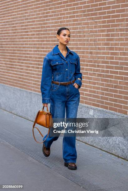 Guest wears denim jacket, jeans, brown bag outside Fendi during the Milan Fashion Week - Womenswear Fall/Winter 2024-2025 on February 21, 2024 in...