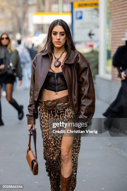 Guest wears brown leather jacket, leopard print skirt outside Fendi during the Milan Fashion Week - Womenswear Fall/Winter 2024-2025 on February 21,...