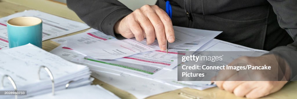Man working at his desk at home, studying energy bills