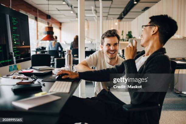 happy multiracial computer programmers laughing while working at tech-startup office - colleague stock pictures, royalty-free photos & images