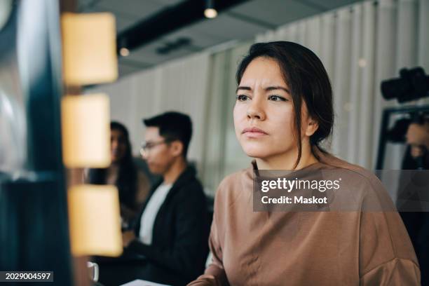 confused female computer programmer working at office - verward stockfoto's en -beelden