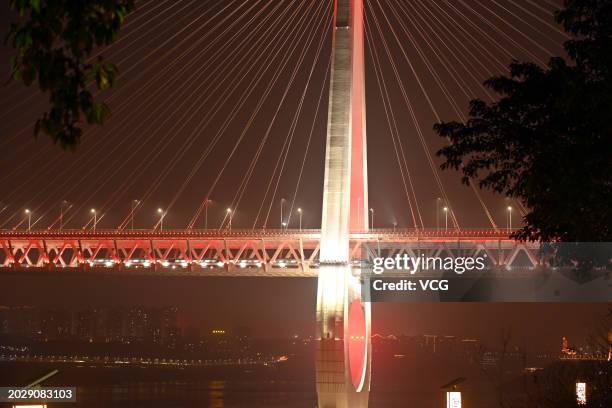 Chongqing Baijusi Yangtze River Bridge is illuminated at night on February 20, 2024 in Chongqing, China. The Baijusi Yangtze River Bridge with a...