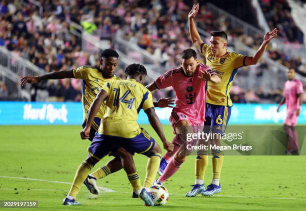 Lionel Messi of Inter Miami dribbles as Rubio Rubin and Braian Ojeda of Real Salt Lake defend during the second half at Chase Stadium on February 21,...